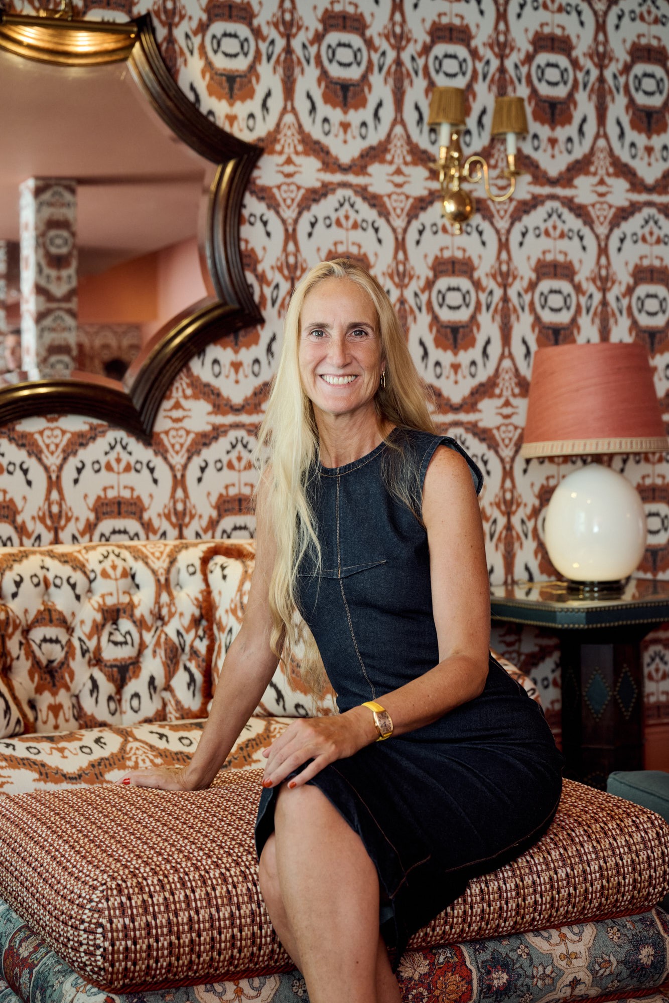 Cristina Lozano, founder of Cristine Bedfor, seated in the vibrant lounge of Casa Cristine Bedfor Sevilla.
