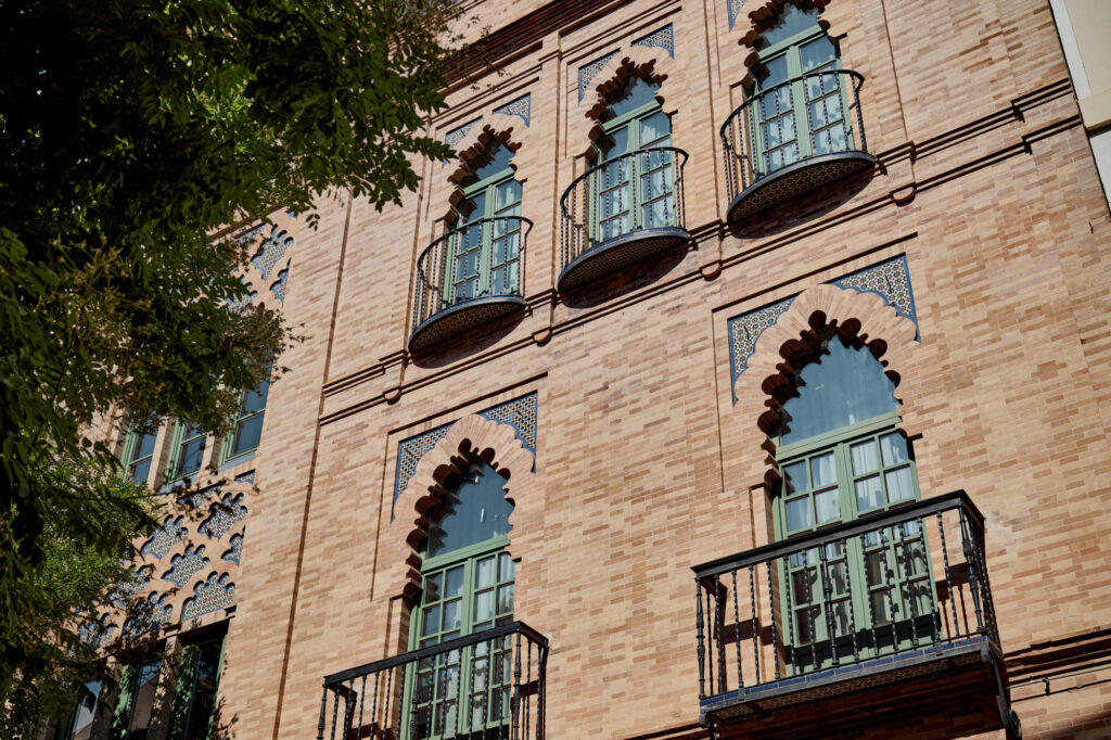 Exterior façade of Casa Cristine Bedfor Sevilla, a neo-Mudejar architectural gem by Aníbal González.
