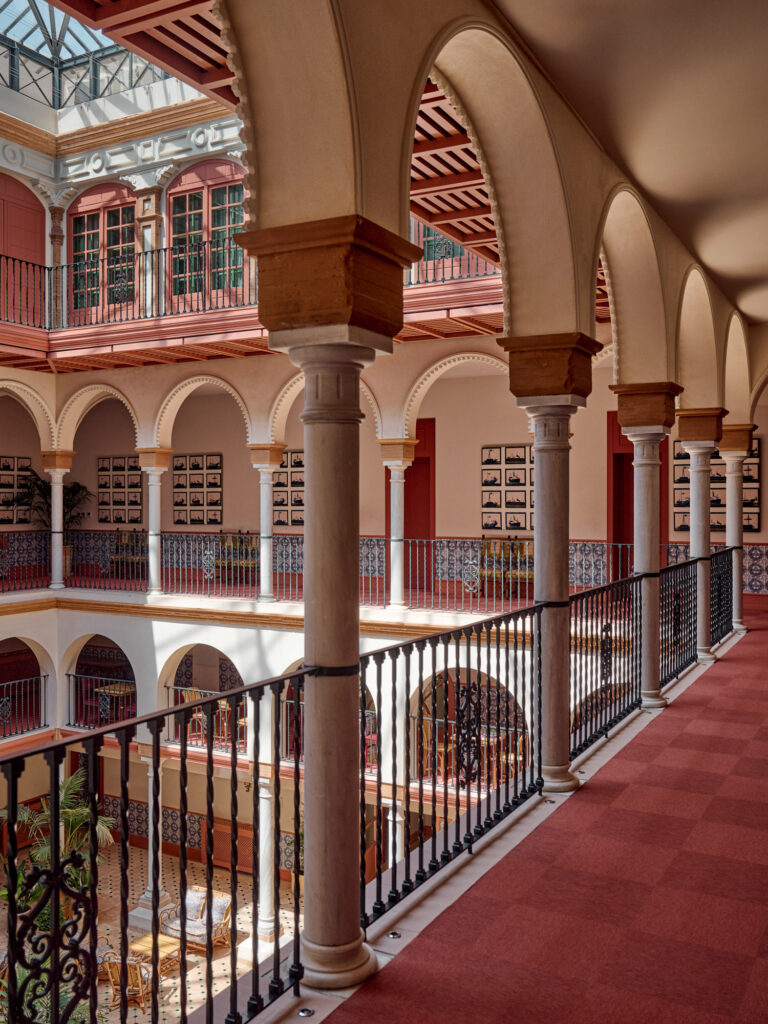 Neo-Mudejar arches and galleries inside Casa Cristine Bedfor Sevilla’s central courtyard.
