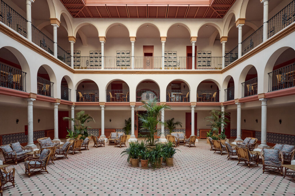 Interior courtyard of Casa Cristine Bedfor Sevilla with elegant arches and classic decor.