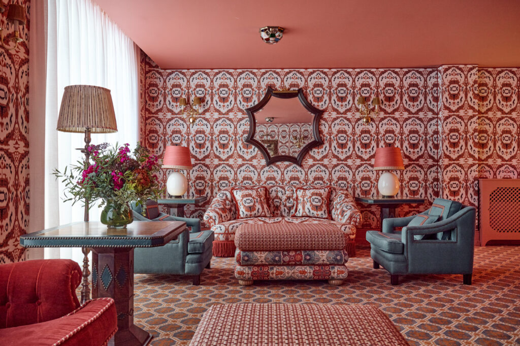 Lounge at Casa Cristine Bedfor Sevilla with patterned walls and vintage-inspired furniture.