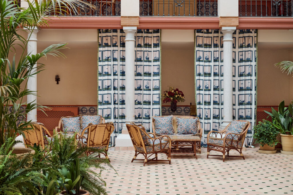 Interior courtyard of Casa Cristine Bedfor Sevilla with Andalusian tiles and elegant seating.