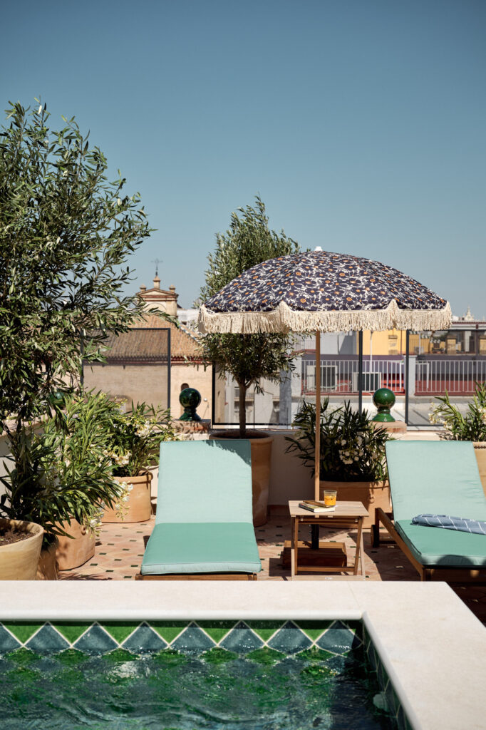 Rooftop pool at Casa Cristine Bedfor Sevilla with sun loungers and city views.