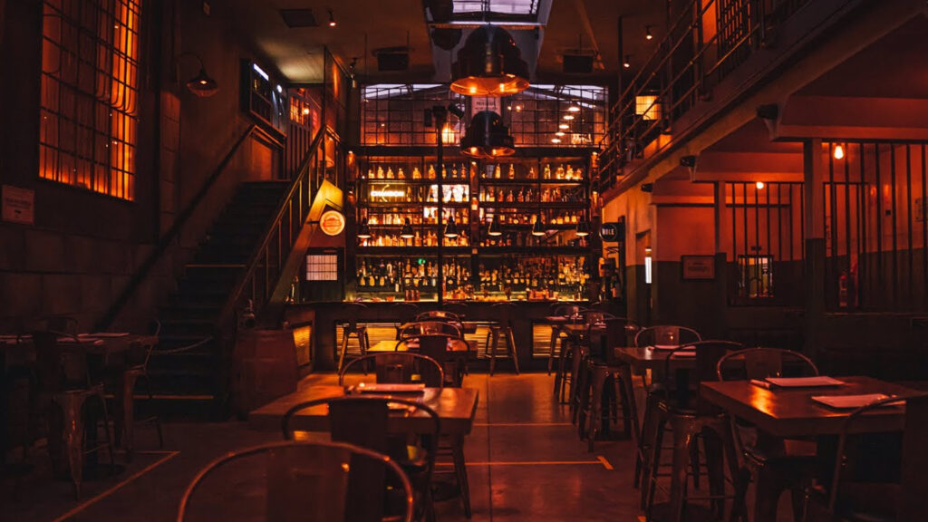 Dimly lit speakeasy interior of The Hole Bar in Buenos Aires with industrial prison-style design